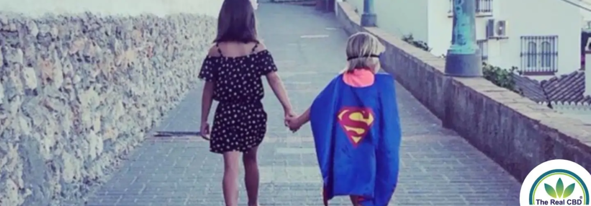Girl holding hands with child superman