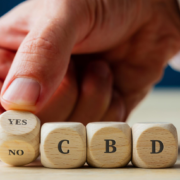 Man hand spelling out YES CBD in wooden dice