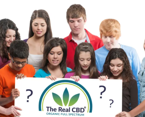 Teenager schauen auf ein Schild mit dem Logo von The Real CBD