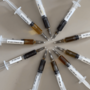 10 seringues contenant différentes huiles de CBD disposées en cercle, montrant la différence de couleur.