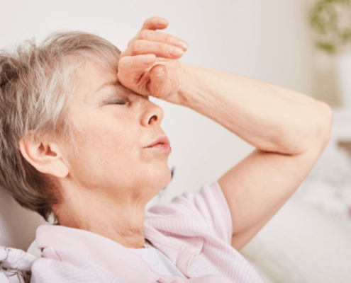 Woman with closed eyes holding her forehead in pain