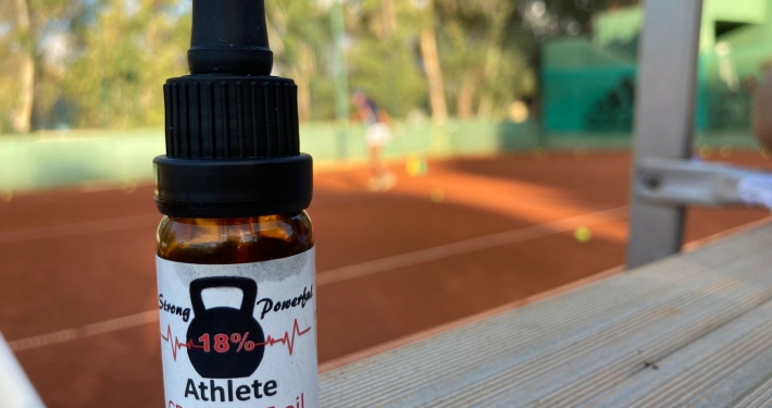 The Real CBD tincture on a tennis court background