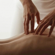 Hände massieren den Rücken einer Frau