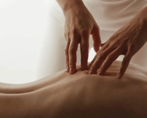 Mains massant le dos d'une femme