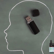 Umriss eines Kopfes, gezeichnet auf einer Tafel mit einem USB-Stick im Inneren.