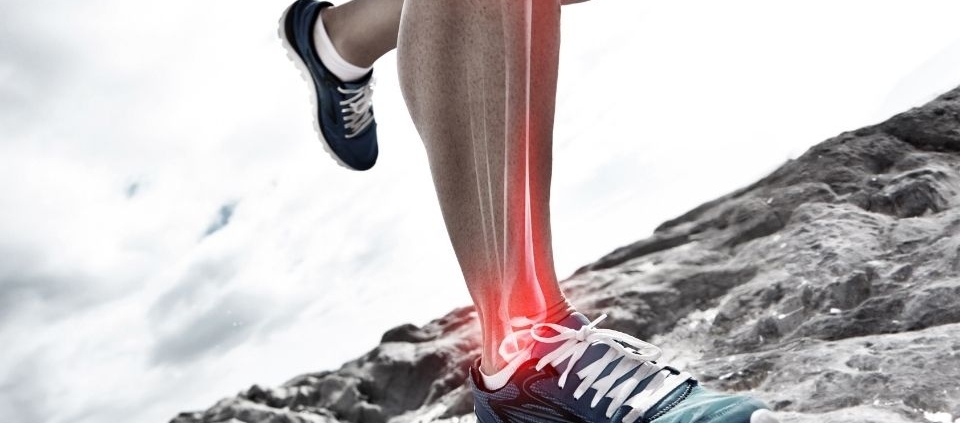 Runner's foot on rocky grounds with ankle bones highlighted in red