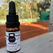 The Real CBD tincture on a tennis court background