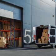 White van with open doors in front of a warehouse