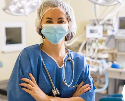 A nurse with a mask on standing in an operating room
