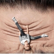 Upside down child holding onto wrinkled forehead