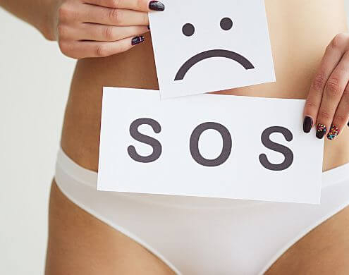 Woman holding SOS sign over her pelvis