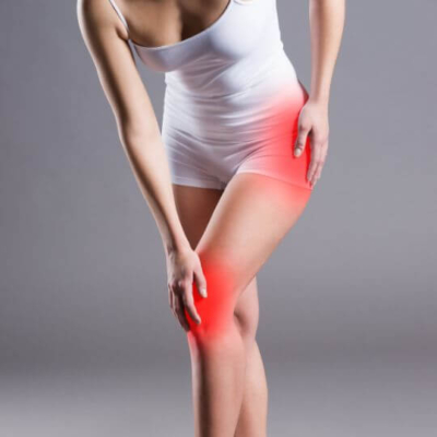 Woman holding her hip and knee in pain