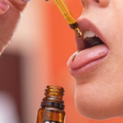 Woman taking CBD oil on the tongue