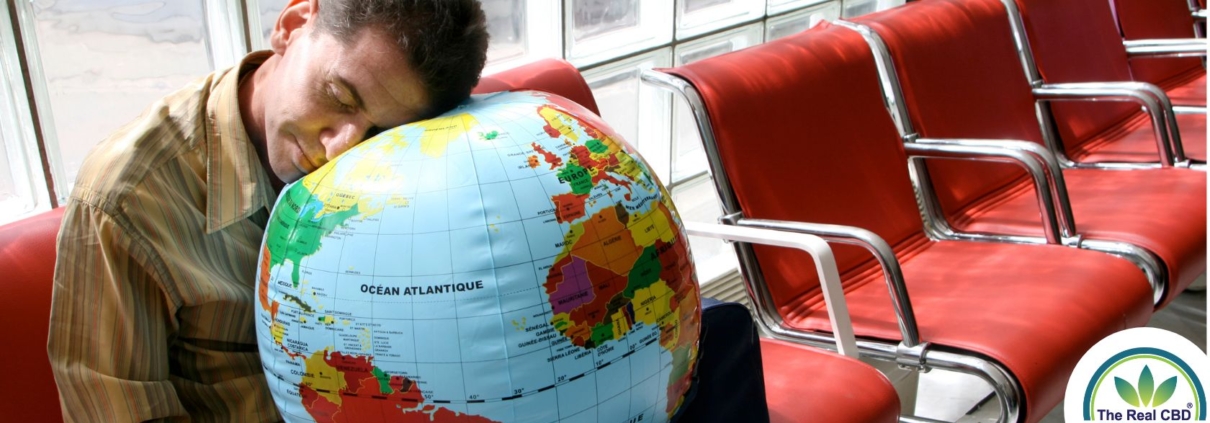 Man sleeping with his head on a globe in an airport