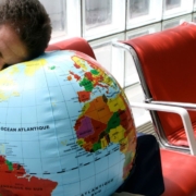 Homme dormant la tête sur un globe dans un aéroport
