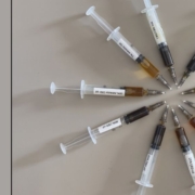 10 kreisförmig angeordnete Spritzen, die verschiedene Farben von CBD-Öl zeigen