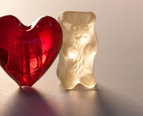 Deux ours en gomme blanche avec un cœur en gomme rouge entre les deux.