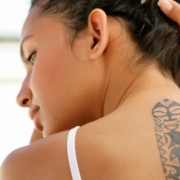 Woman lifting her hair to reveal a tattoo