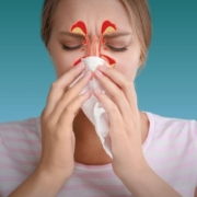 Woman blowing her nose with drawing illustrating her blocked sinuses