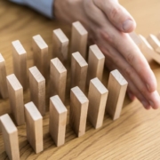 Main empêchant les briques de bois de tomber comme des dominos