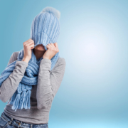 Woman tugging a blue knitted hat over her head