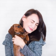 Woman holding a dog that licks her face