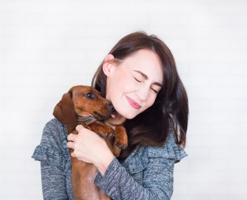 Woman holding a dog that licks her face