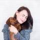 Woman holding a dog that licks her face