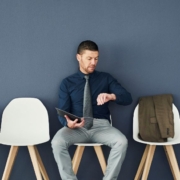 Homme regardant sa montre dans une salle d'attente