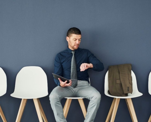 Homme regardant sa montre dans une salle d'attente