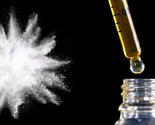 White powder explosion and CBD oil on black background