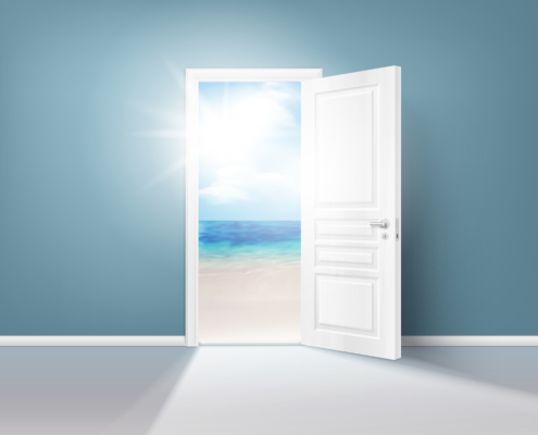 White door open onto a beach with sunlight