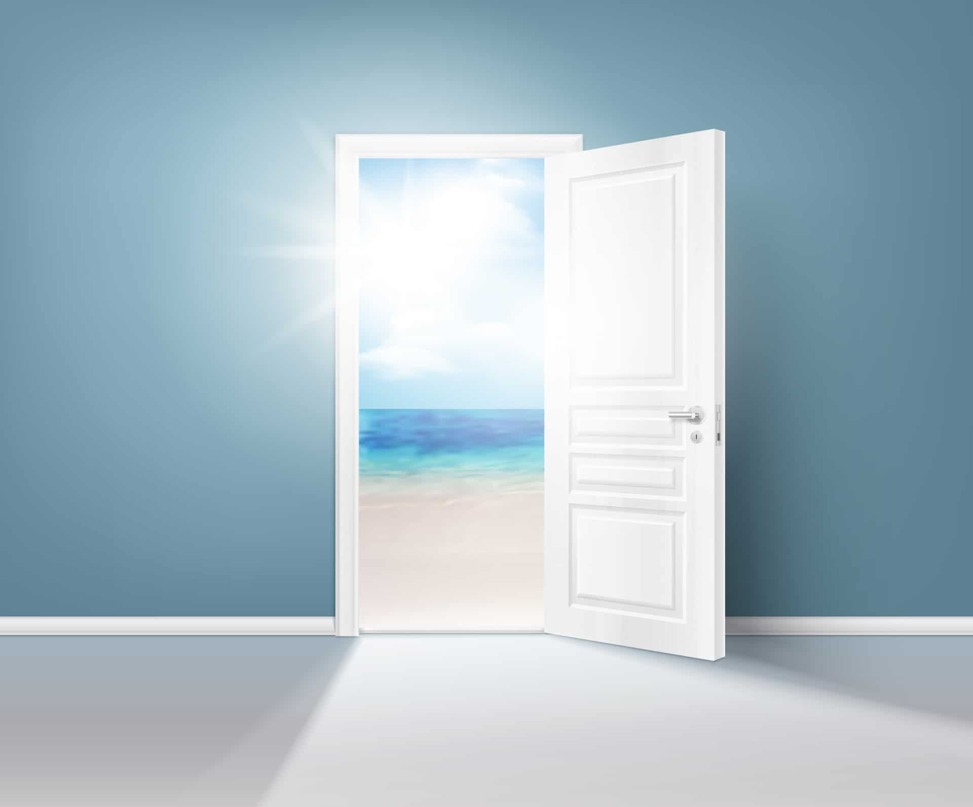 White door open onto a beach with sunlight