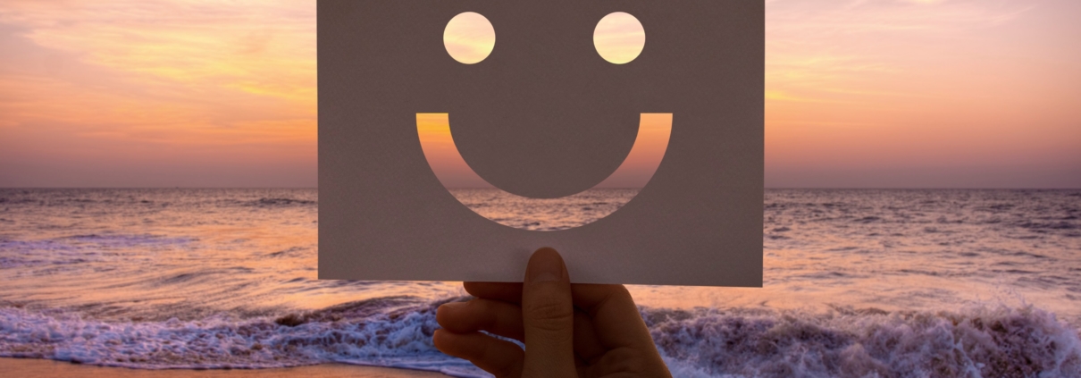 Smiley-Gesicht über dem Meer bei Sonnenuntergang