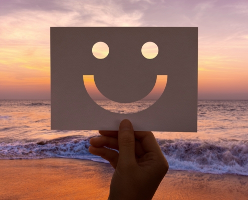 Visage souriant sur la mer lors d'un coucher de soleil