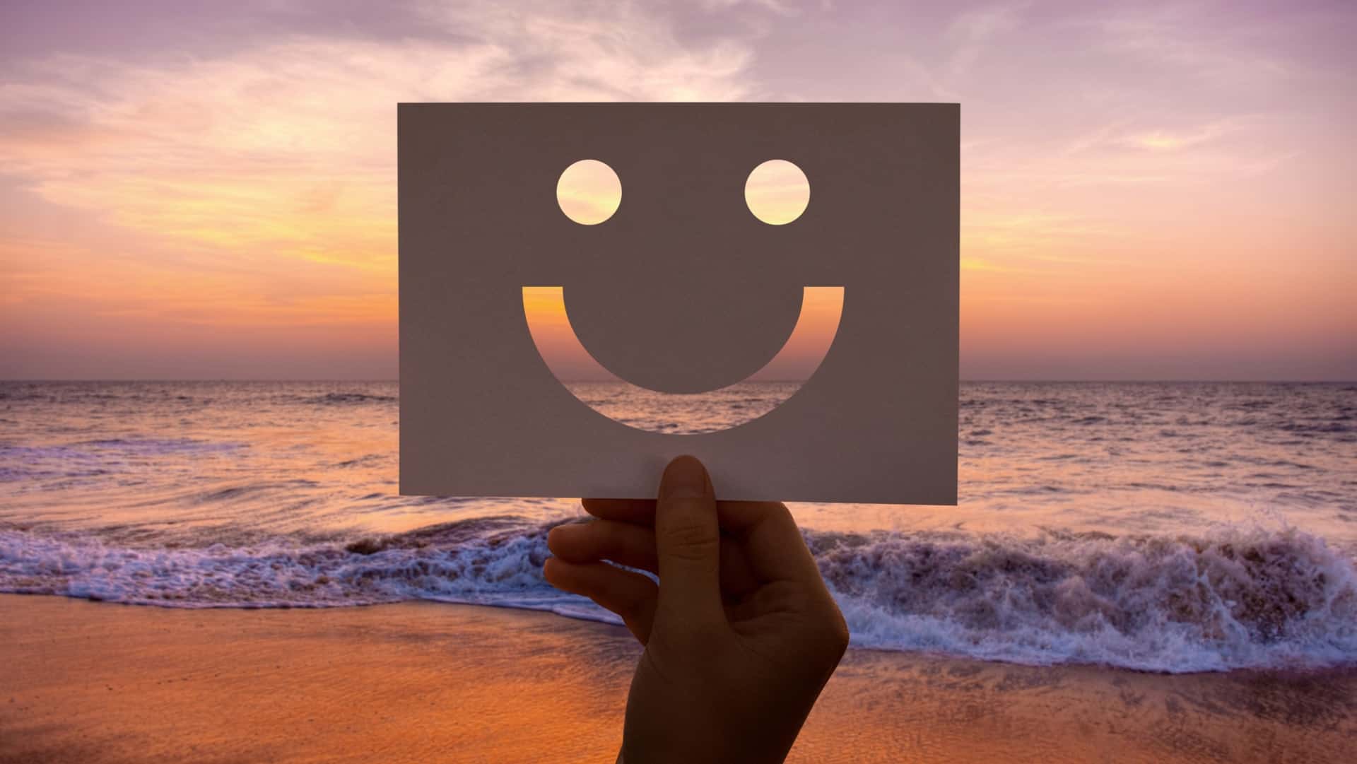 Smiley-Gesicht über dem Meer bei Sonnenuntergang