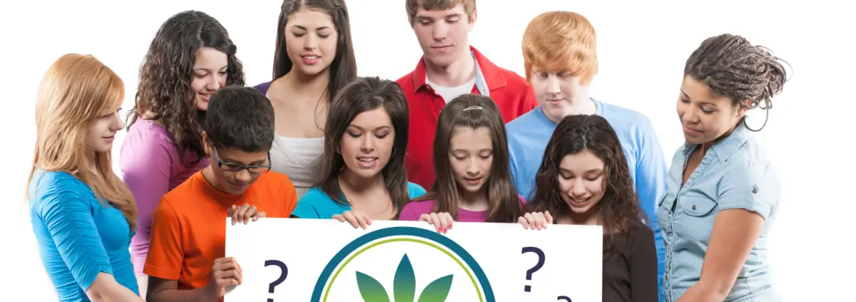 Teenagers looking down at a sign with The Real CBD logo