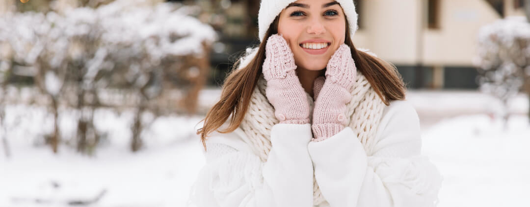 Woman in snow scene looking happy and smiling