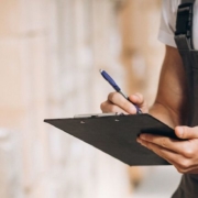 Entreposeur tenant une planchette à pince et faisant l'inventaire