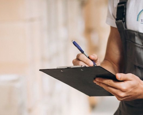 Entreposeur tenant une planchette à pince et faisant l'inventaire