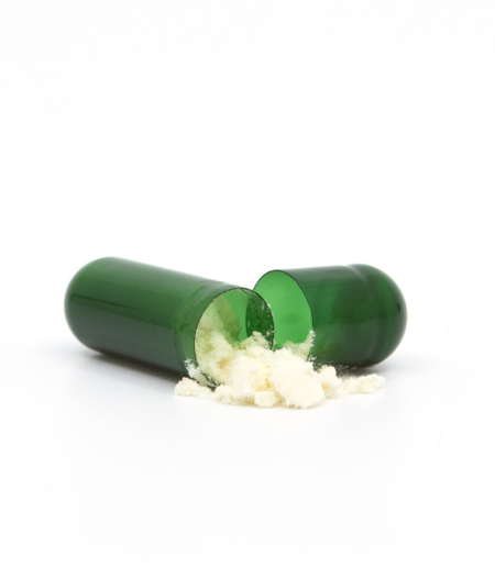 Les capsules de CBD vertes s'ouvrent et laissent échapper de la poudre de CBD - The Real CBD Brand