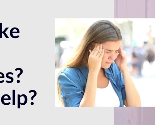 Woman holding her head in front of a migraine road sign