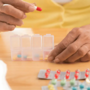 Hands putting pills in to pill organiser