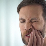 Man holding his tooth in agony