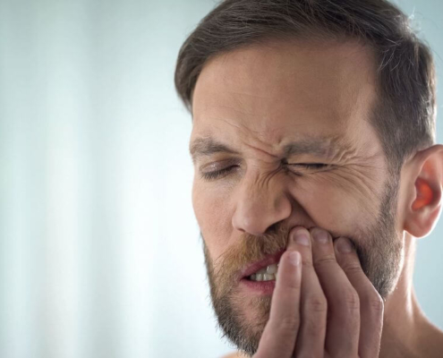 Man holding his tooth in agony