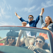 Eine Gruppe junger Leute, die in einem Cabrio fahren und sich amüsieren