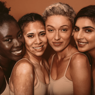 4 women of different ethnic background smiling