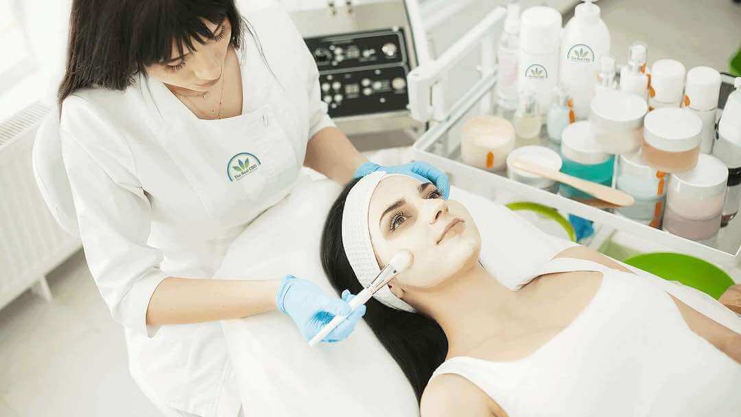 Beautician giving a woman a facial treatment in a beauty salon