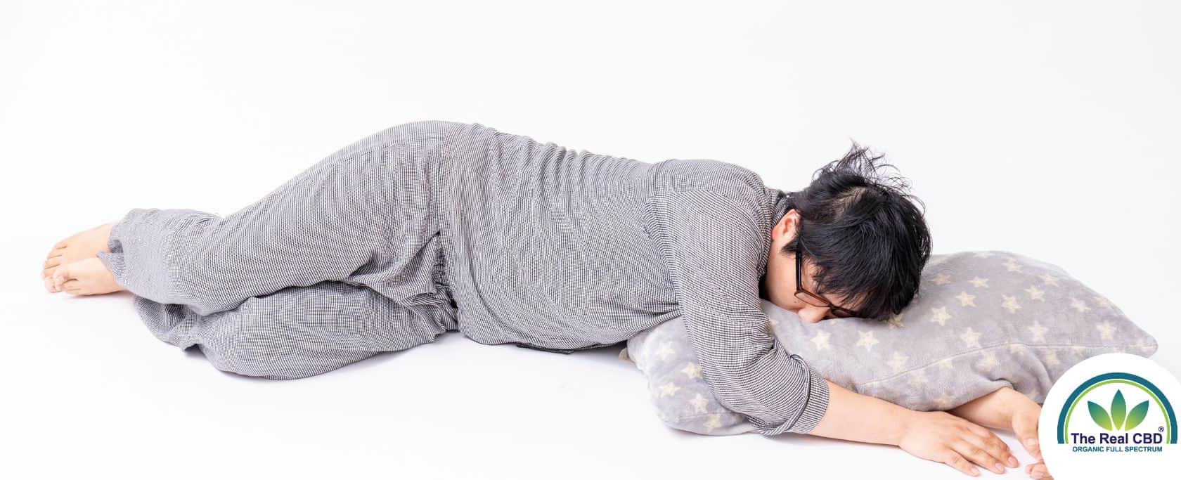 Person sleeping on the floor in grey pyjamas