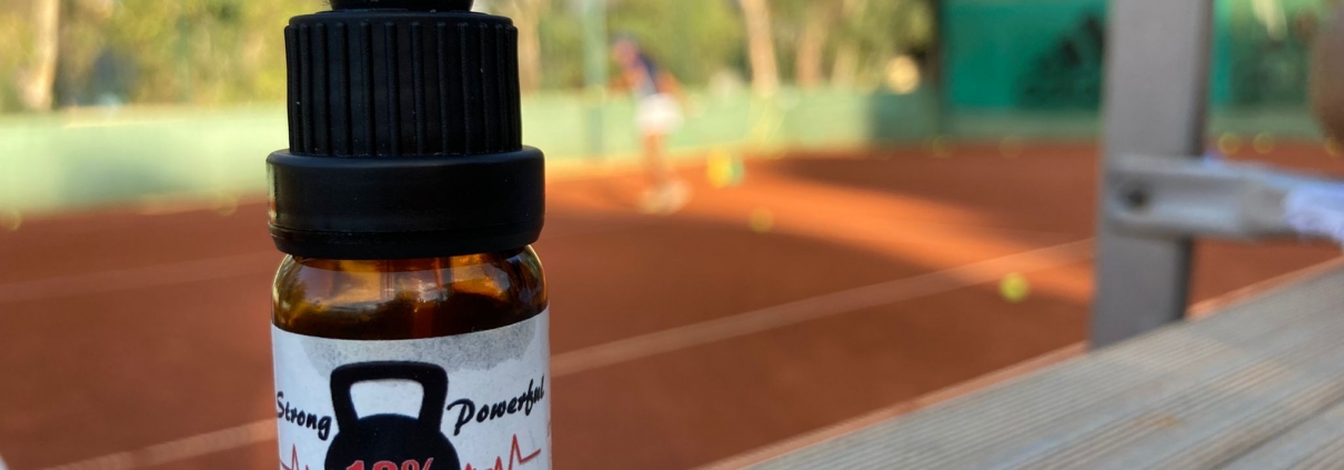 The Real CBD tincture on a tennis court background